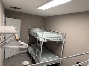 A bunk bed room with a white door, a white shelf, and a ceiling vent. - A HomeAwayFromHome
just 2 miles from Kyle
Field. (College Station)