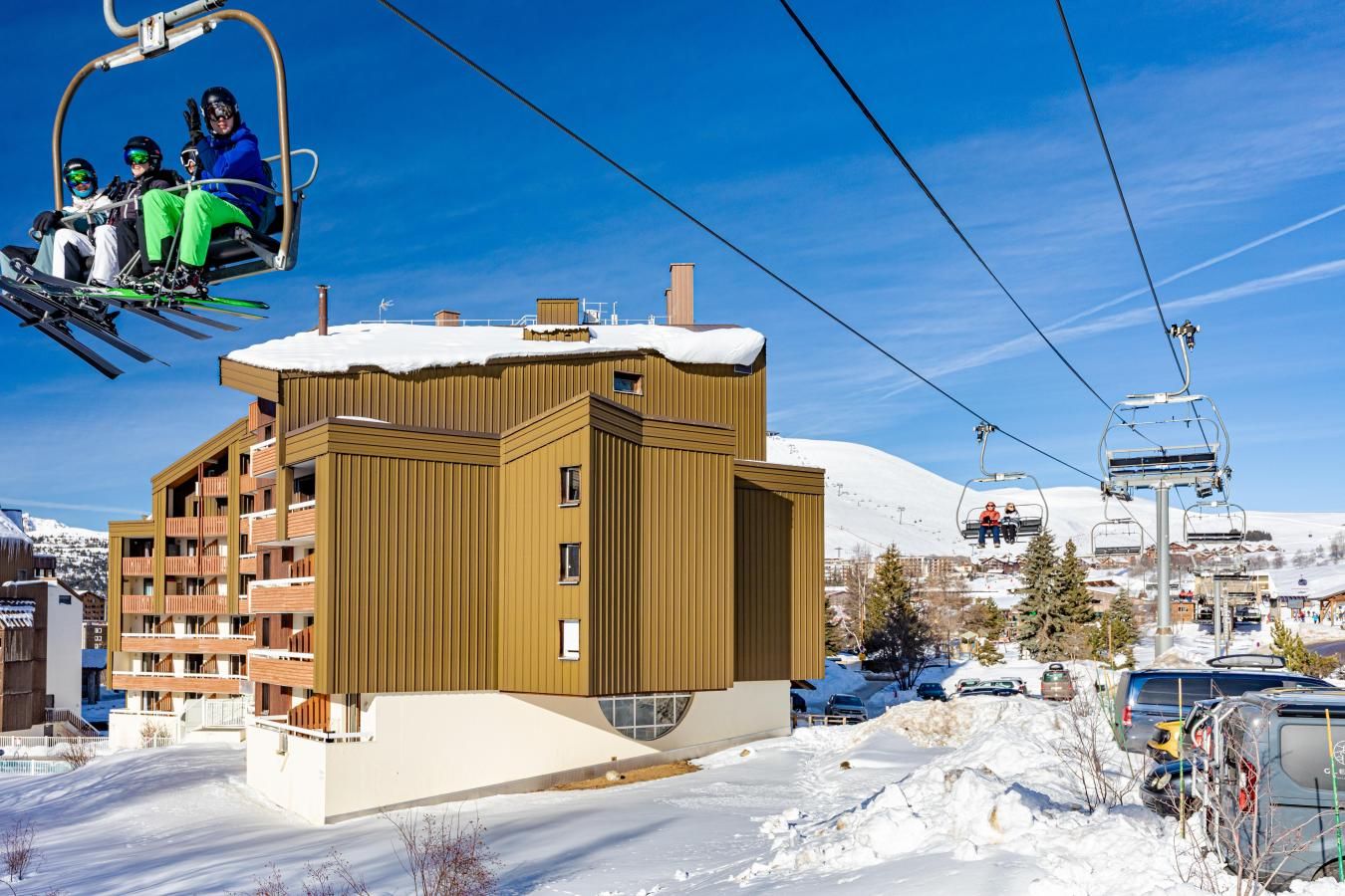 Ein Skigebiet mit einem modernen Gebäude, Seilbahnen und verschneiter Landschaft.