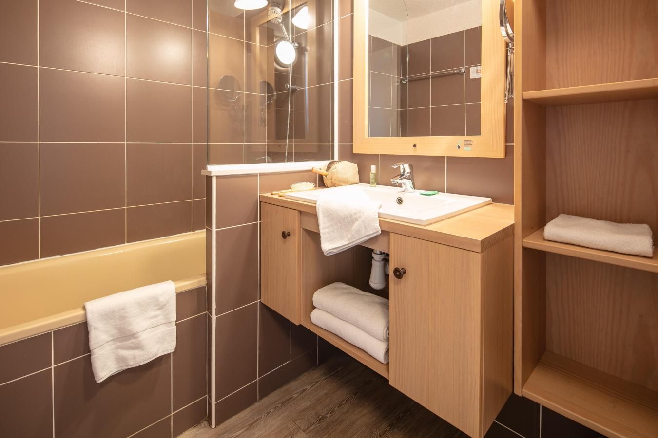 A bathroom with a bathtub, a sink, a mirror, and a shower.