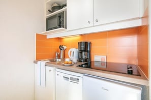 A compact kitchen with a microwave, coffee maker, and a dish rack. - Wifi, 100m from ski slopes, swimming pool, sauna, balcony, ski locker, 28-32m², Alpe d'Huez (L'Alpe d'Huez)