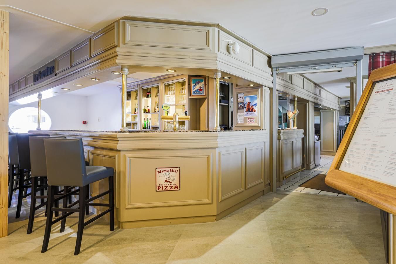 A bar area with a sign for 'Mama Mia! That's a tasty pizza.'