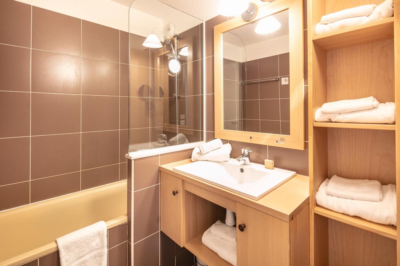 A modern bathroom with a bathtub, a sink, and a mirror.