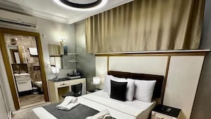 A hotel room with a bed, bedside table, and a mirror. - Leili Hagiya Sofiya Hotel (Fatih)