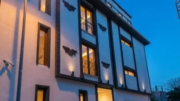 A building with a cobblestone street, a balcony, and a table with chairs outside. - Leili Hagiya Sofiya Hotel (Fatih)
