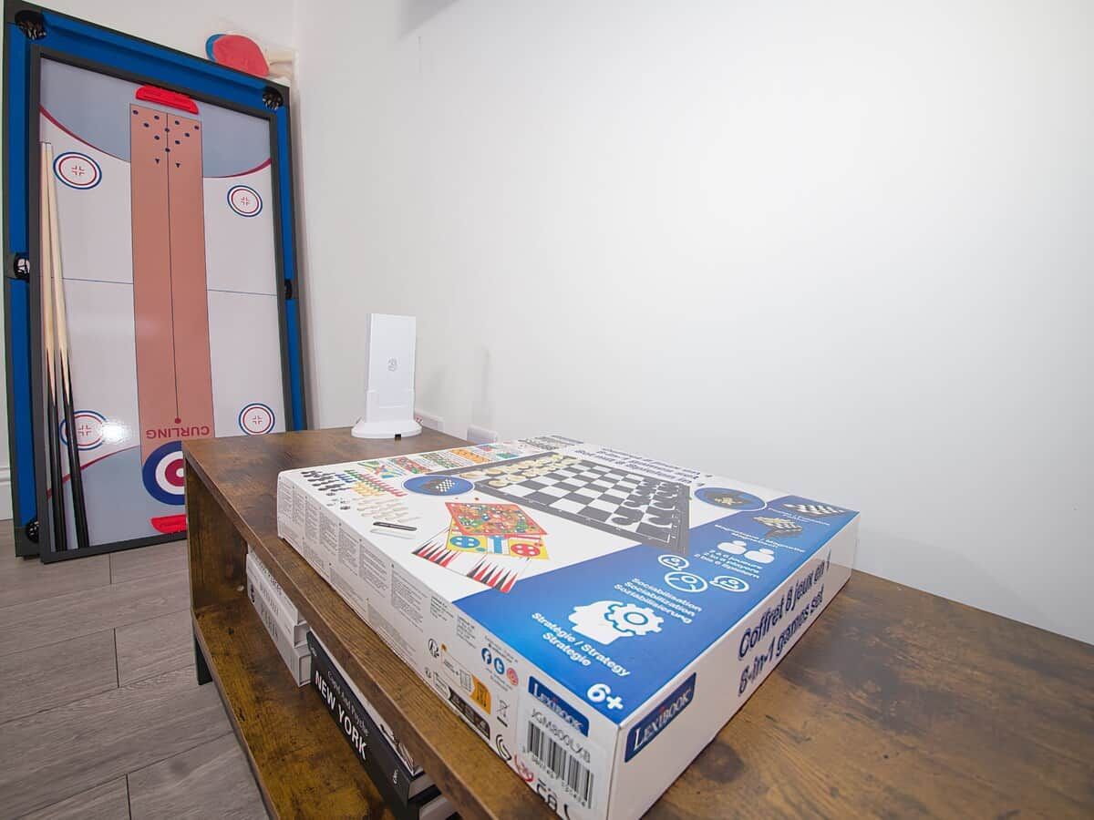 A table with a board game box in a room with a door in the background.