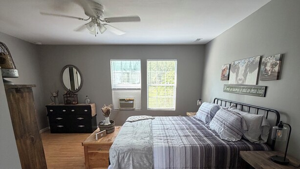 A bedroom with a bed, dresser, bedside table, and a ceiling fan. - Escape to Gayles Farmhouse and discover your perfect mountain getaway. (Trenton)
