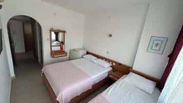 Ein Hotelzimmer mit Doppelbett, Nachttisch mit Lampe, Spiegel, kleiner Nachttisch mit Fernbedienung und einem Bild an der Wand.