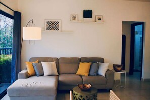 A modern living room with a sectional sofa, a side table, and a wall-mounted lamp.