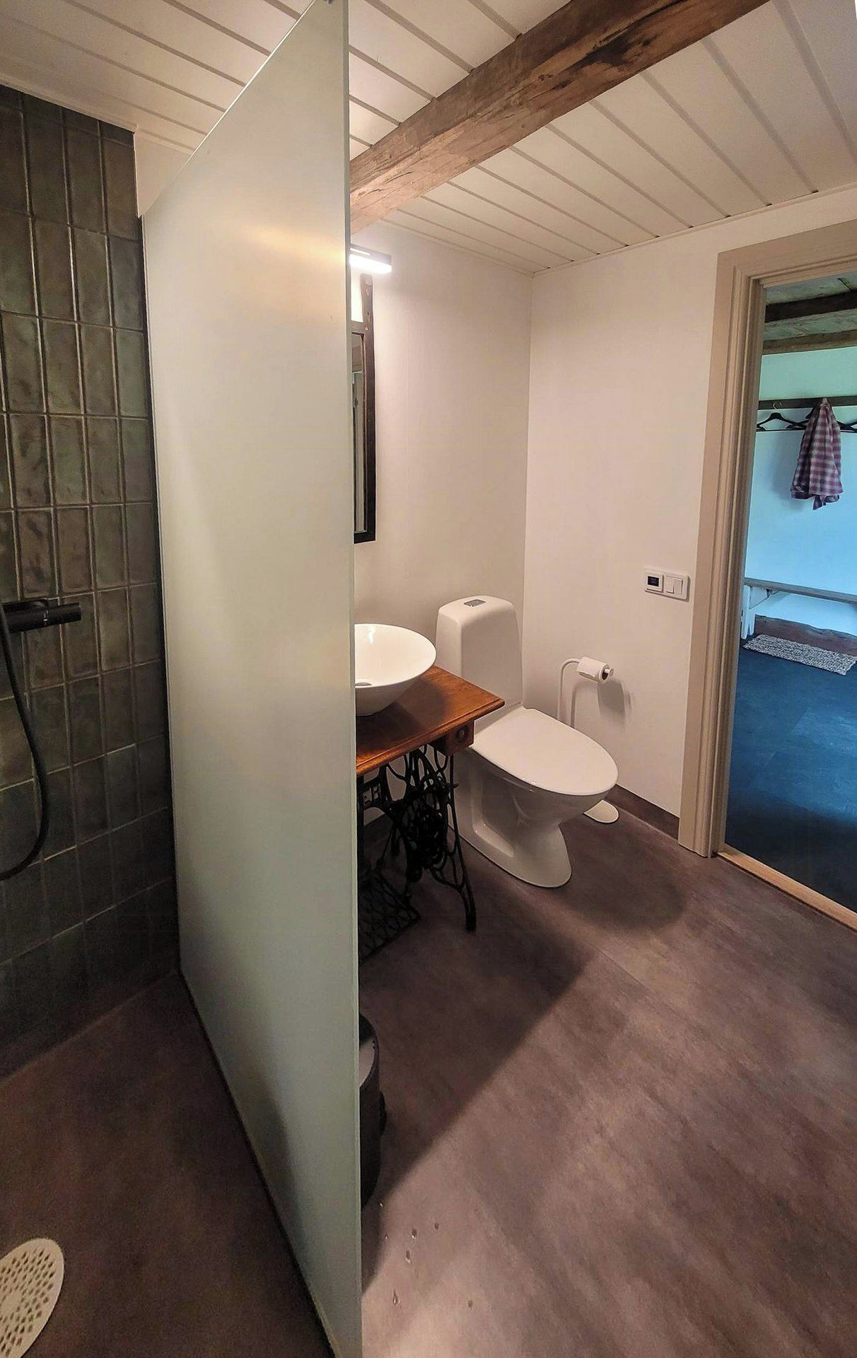 Een badkamer met toilet, wastafel en douchehoek.