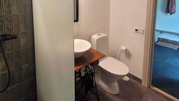 Een badkamer met toilet, wastafel en douchehoek.