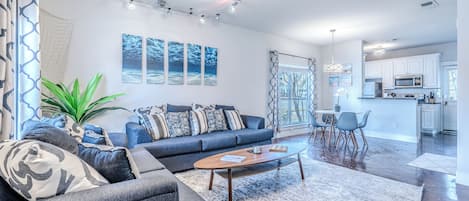 Una sala moderna con sofá, mesa de centro y ventilador de techo.