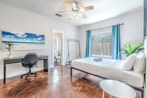 A bedroom with a bed, a desk, a chair, a ceiling fan, and a window with curtains. - Spacious 3BR Downstairs Home Near TCU - Fort Worth (Fort Worth)
