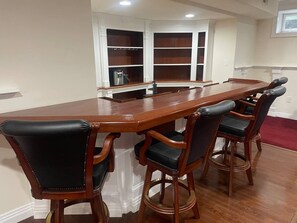A dining area with a long wooden table and four upholstered chairs. - Luxury Estate on Green w pool, gym & theatre (Middle Township)