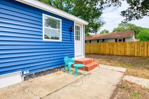 A blue house with a white door, a window with blinds, and a wooden fence in the background. - Salt Air Cottage•Pet Friendly•Fire Pit•EV Charger• (Lower Township)