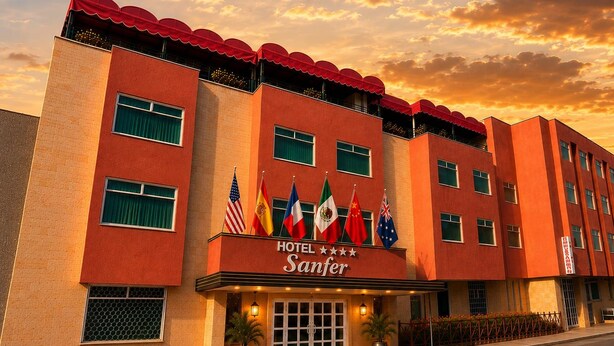 Un hotel con fachada roja, varias banderas y un cartel que dice 'HOTEL Sanfer'.