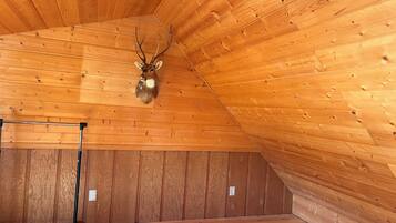 A wooden ceiling with a deer head mounted on the wall.
