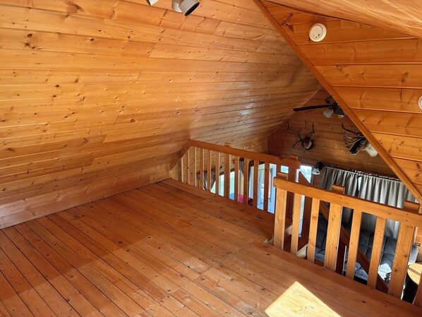 A wooden interior with a staircase, wooden walls, and a ceiling with a light fixture. - 1-bedroom cabin in Soldotna perfect for a cozy getaway near the Kenai River (Soldotna)