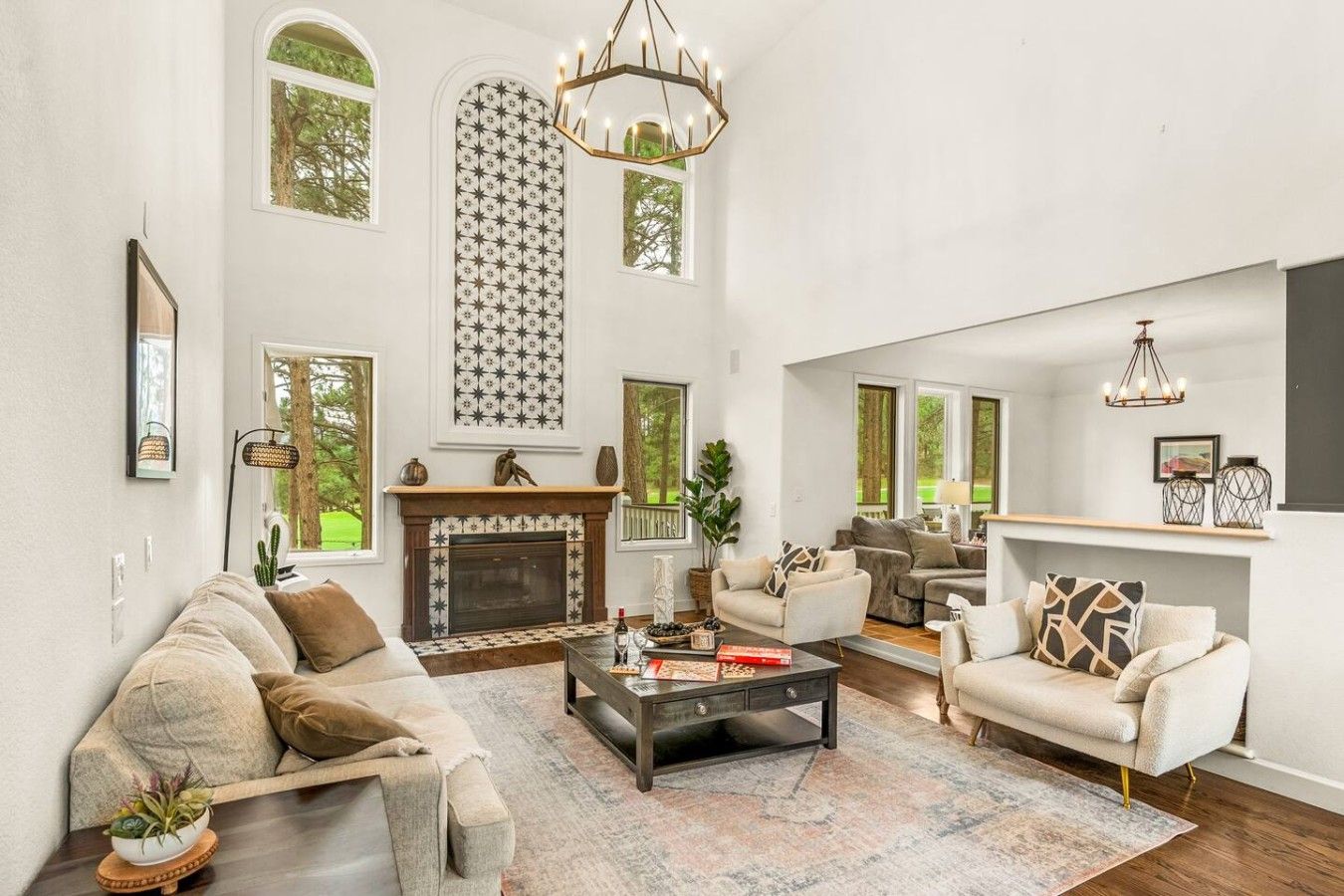 A spacious living room with a fireplace, comfortable seating, and large windows.