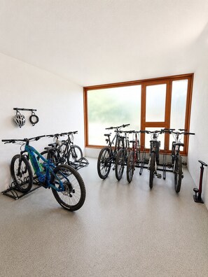 Ein Zimmer mit Fahrrädern, die an der Wand lehnen, und einem großen Fenster.