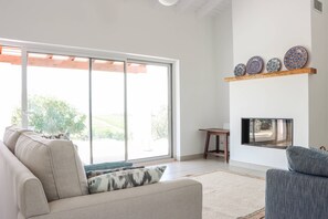 A modern living room with a sofa, a TV, and a fireplace.