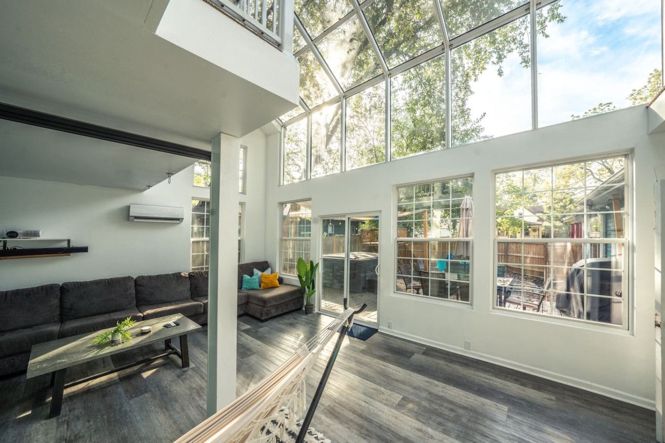 Ein großzügiger Wohnbereich mit einem großen Fenster, einem Sofa und einem Couchtisch.