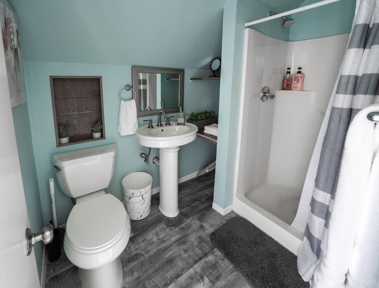 A bathroom with a toilet, sink, and shower.