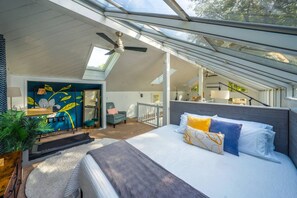 A bedroom with a skylight, a bed, a desk, and a chair. - Treehouse - Sleeps 14, Hot Tub, 2-Story Solarium (Sioux Falls)