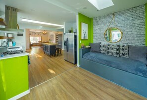 A modern kitchen with a dining area, a sofa, and a large mirror. - Treehouse - Sleeps 14, Hot Tub, 2-Story Solarium (Sioux Falls)