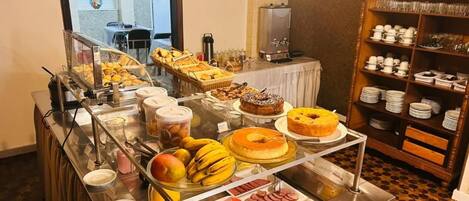 A buffet with various food items, a coffee machine, and a glassware rack.