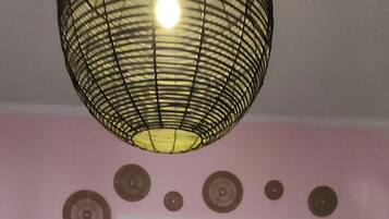 An interior space with a patterned ceiling light, a door leading to another room, and a wall with circular decorations.