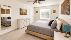 A bedroom with a bed, dresser, mirror, ceiling fan, artwork, and a window. - Spacious 3BR - 2 Kings, Pool Table + Patios (Centennial)