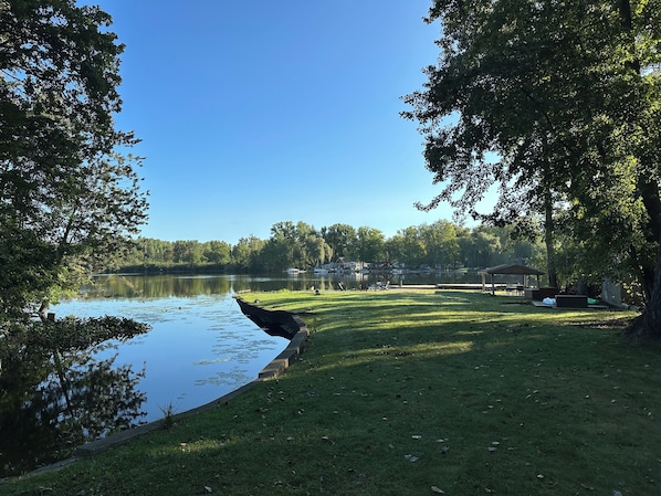 A lakeside park with a grassy area, a dock, and a gazebo. - Serene Lake Retreat with Northern Michigan Feel - 20 Minutes from Ann Arbor (South Lyon)