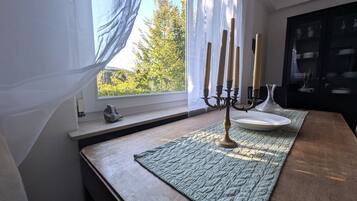 A room with a window, a candelabra, a plate, and a cabinet.