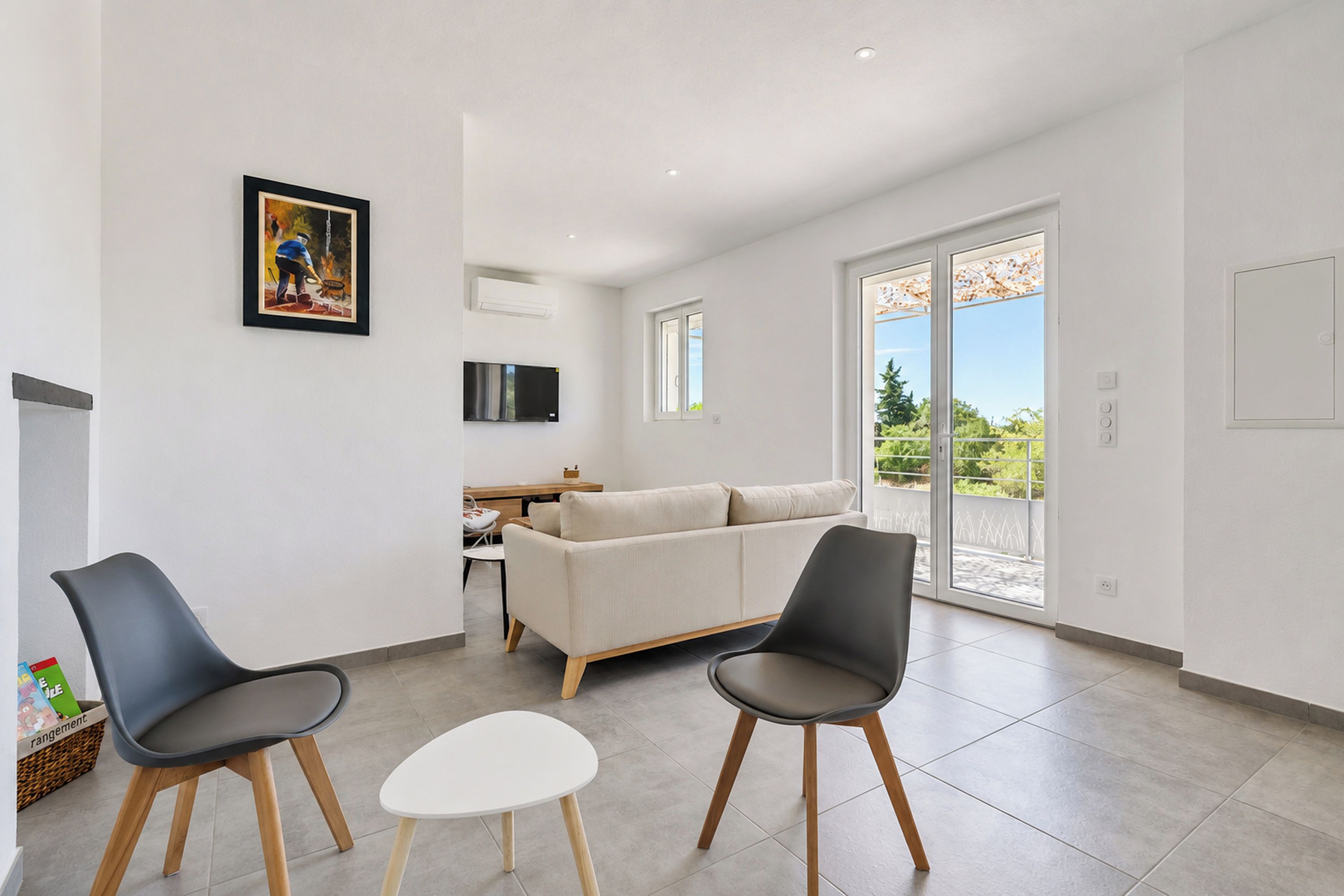 Uma sala de estar moderna com um sofá, duas poltronas, uma mesinha e uma televisão.