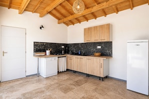 Eine Küche mit Holzausstattung, einem weißen Kühlschrank und einer Marmor-Spritzschutzwand.
