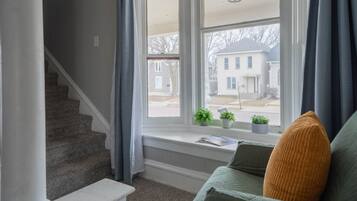 A staircase leading to a landing with a window overlooking a residential street.