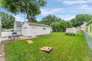 A backyard with a white shed, a barbecue grill, and a lawn with two wooden planters. - Lucky Strike: 3 bed, 5 mins to DT, family-friendly (Sioux Falls)