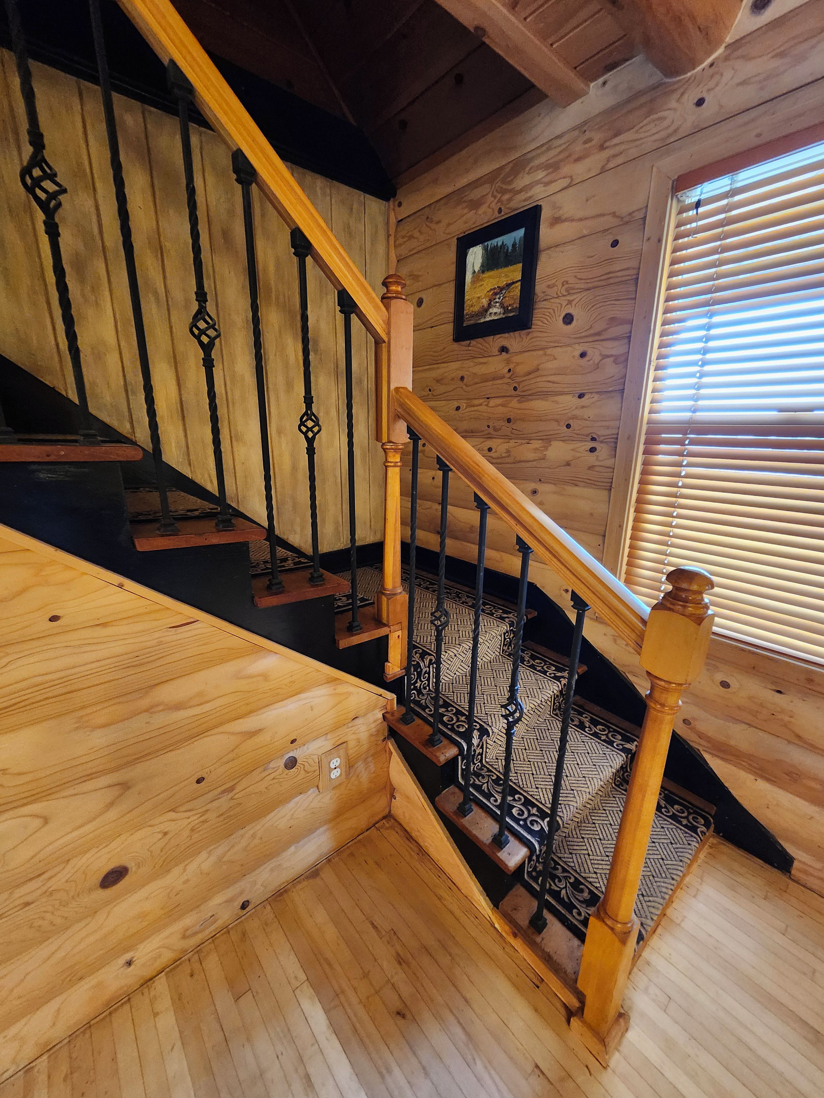 A wooden staircase with a handrail and a patterned floor.