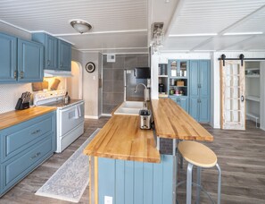 Una cocina moderna con armarios azules, una isla de madera y un refrigerador de acero inoxidable.