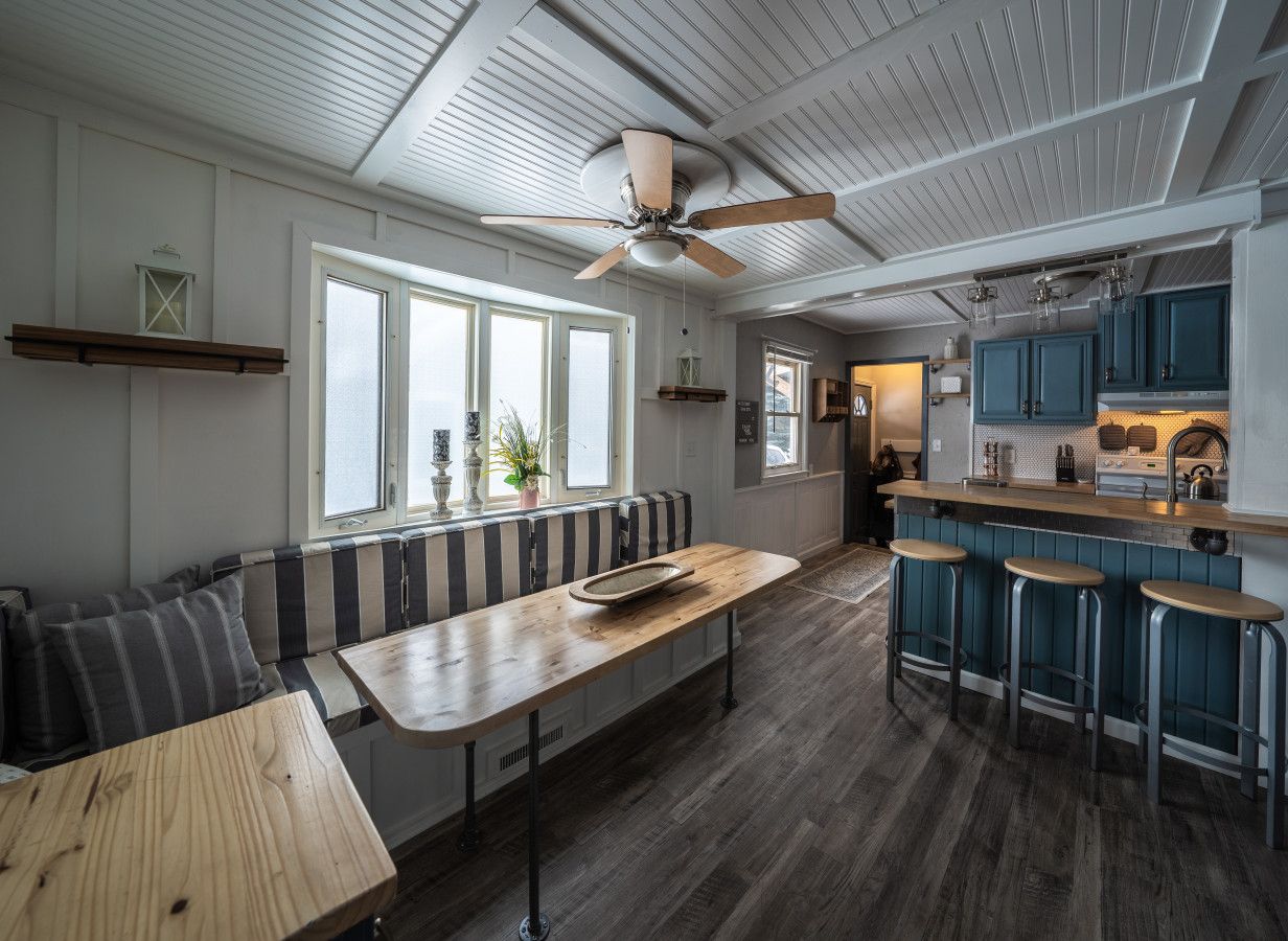 Eine moderne Küche mit Bar, Holzboden und Deckenventilator.