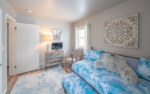 A bedroom with a bed, a dresser, a chair, a window, and a wall art piece. - Duluth Charmer - 3B/2B cozy home (Sioux Falls)