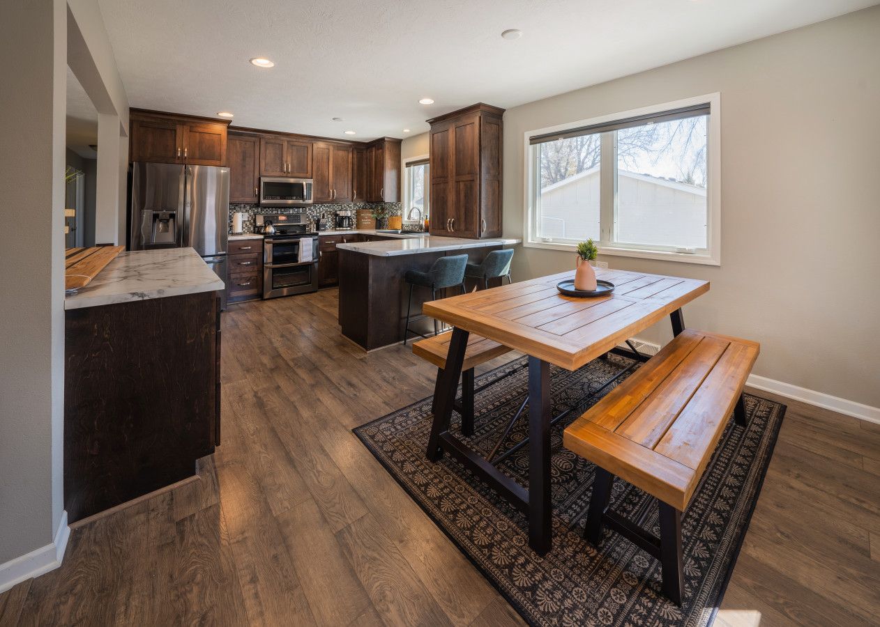 A modern kitchen with dark wood cabinets, stainless steel appliances, and a central island with seating.