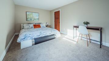 A bedroom with a bed, a desk, and a chair.