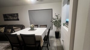 Un comedor con una mesa, sillas, un ventilador de techo y una planta en maceta.