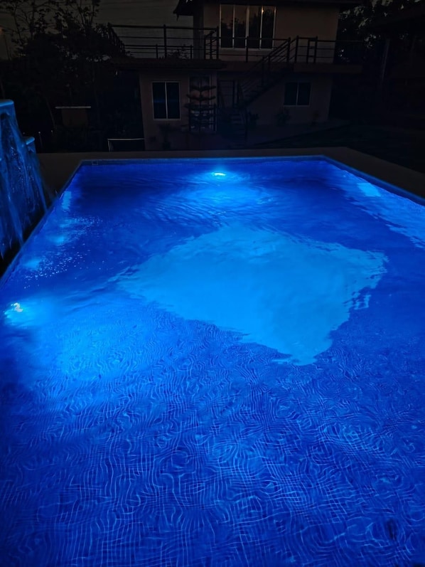 A swimming pool with a textured surface and a central hot tub area.