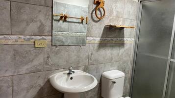Ein Badezimmer mit Waschbecken, Toilette, Spiegel und Duschkabine.
