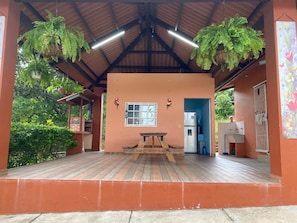 A covered outdoor area with a wooden bench, a window, and hanging plants. - Private Oasis Villa: Pool, BBQ Area & Lush Nature - Family Friendly (Provincia de Panamá Oeste, Corregimiento de Guayabito)