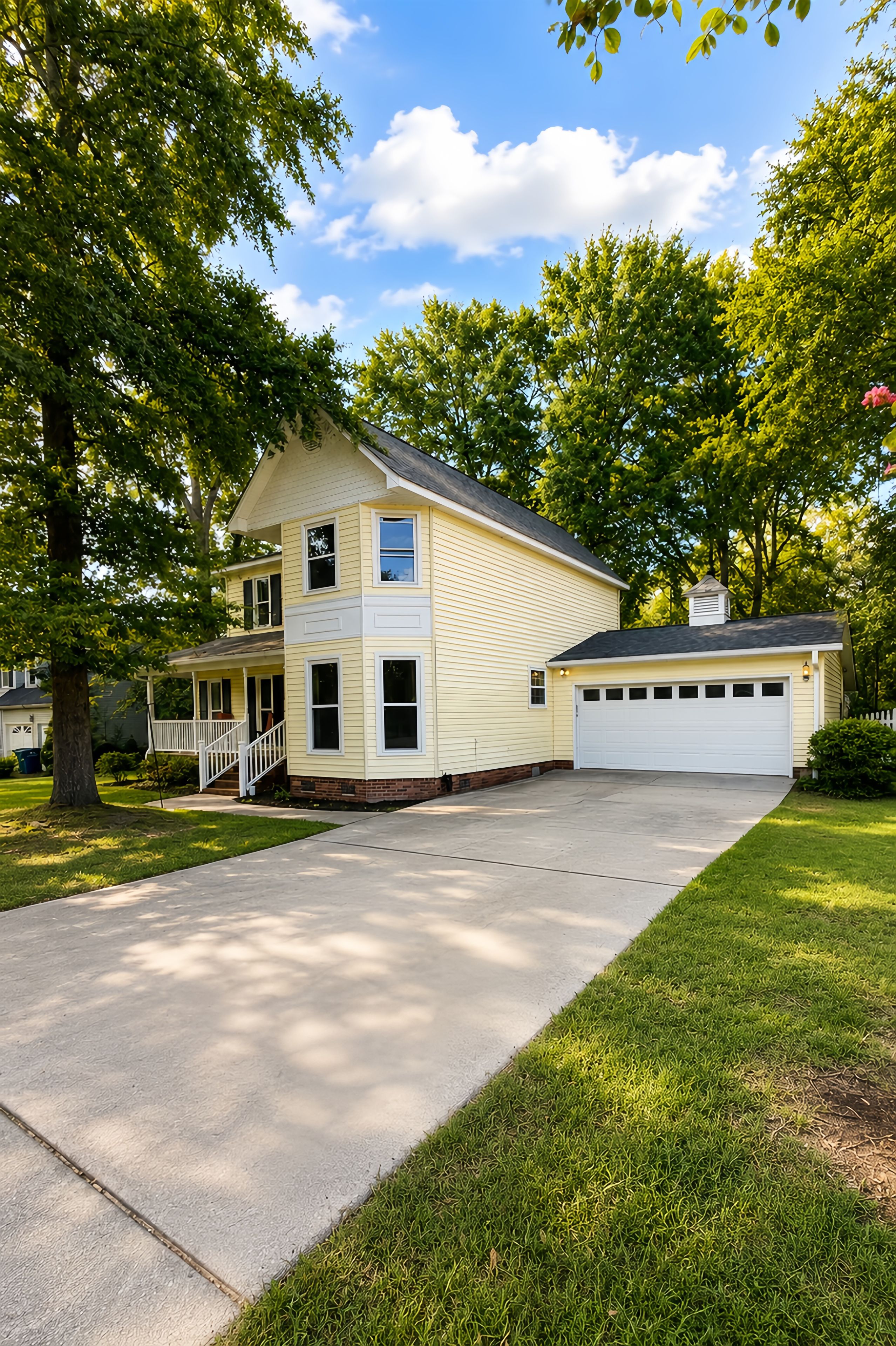 A two-story house with a front porch, a garage, and a driveway.