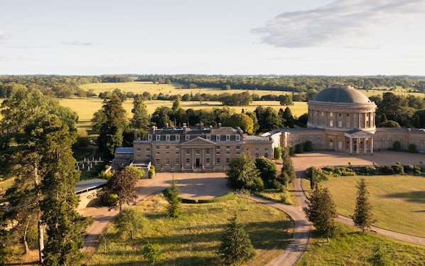 A large estate with a central building featuring a dome, surrounded by expansive lawns and trees. - Village House with open countyside views close by the bustling 'Norton Dog ' pub (Norton)