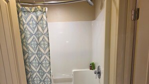 Un baño con ducha, inodoro y lavamanos.
